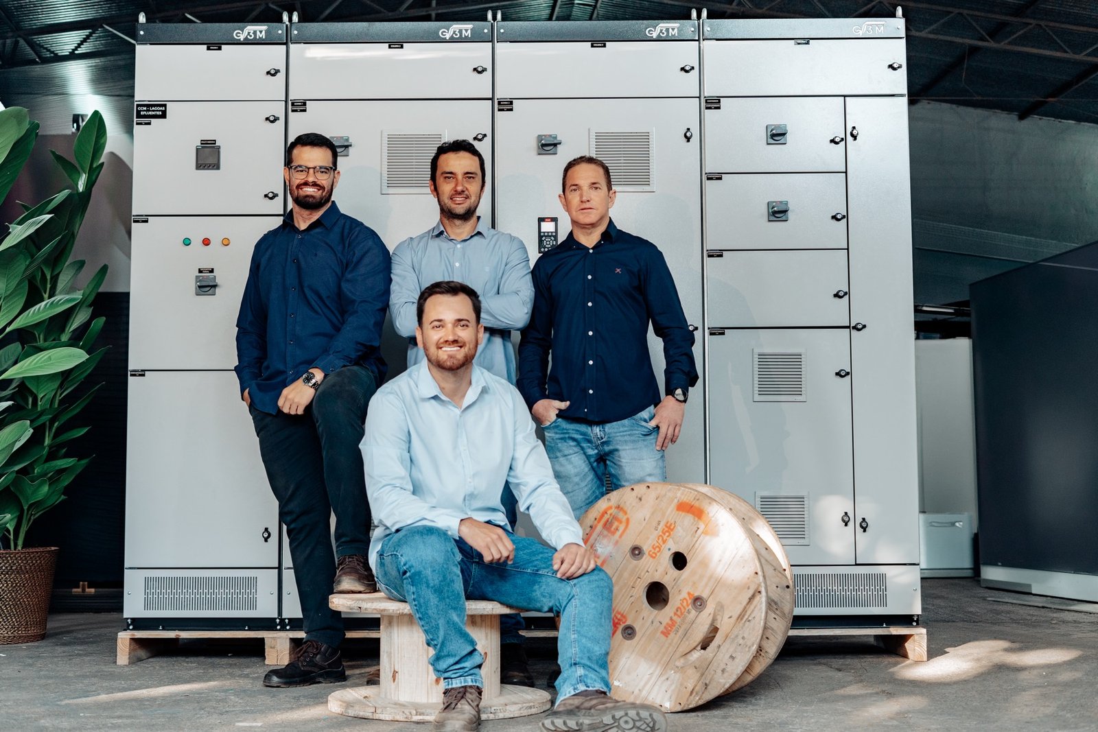Equipe da G3M Engenharia em frente a painéis elétricos fabricados na oficina